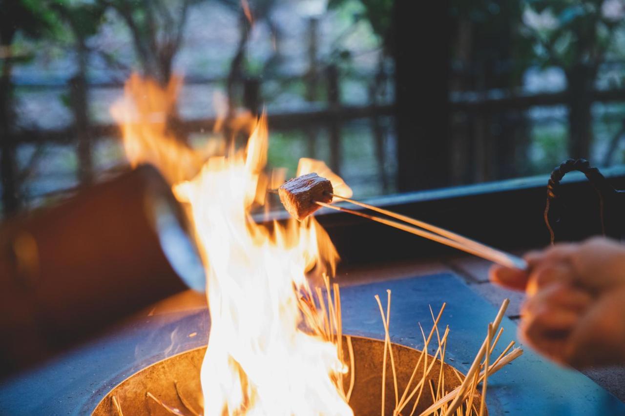 Arima Onsen Tocen Goshobo Hotel Кобе Екстериор снимка A piece of meat being cooked over a fire